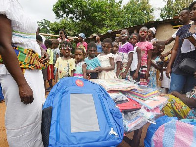 Distribution de cartables solaires conçus par Solarpak à des écoliers de Rubino, le 16 septembre 2018 en Côte d'Ivoire - Sia KAMBOU [AFP]