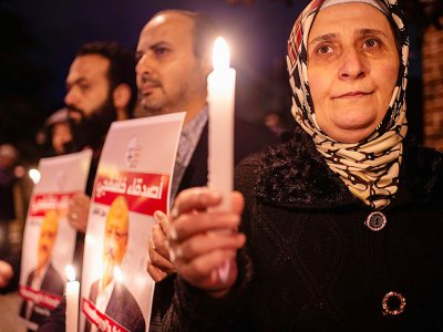 Des manifestants avec des portraits du journaliste  Jamal Khashoggi et des bougies devant le consulat saoudien à Istanbul, le 25 octobre 2018 - Yasin AKGUL [AFP]