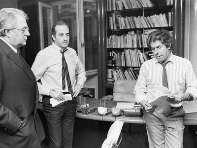 Le journaliste Philippe Gildas (d) et son confrère Jean-Pierre Elkabbach (c) échangent avec le Premier ministre Pierre Mauroy (g) avant une interview à Paris, le 27 mars 1984 - PHILIPPE WOJAZER [AFP/Archives]