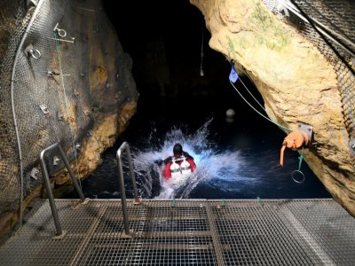 Un plongeur se jette à l'eau depuis la plateforme d'accès aux grottes Janos Molnar, sous Budapest, le 2 octobre 2018 - ATTILA KISBENEDEK [AFP]
