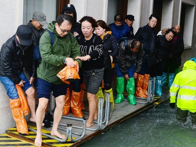 Des touristes marchent sur un passerelle à Venise le 29 octobre 2018 - Miguel MEDINA [AFP]