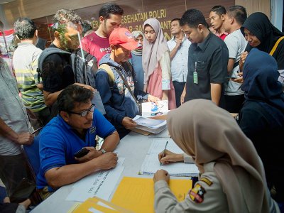 Des familles déposent documents et photographies de leurs proches qui se trouvaient à bord de l'avion de Lion Air, dans un hôpital de Jakarta, le 30 octobre 2018 - BAY ISMOYO [AFP]
