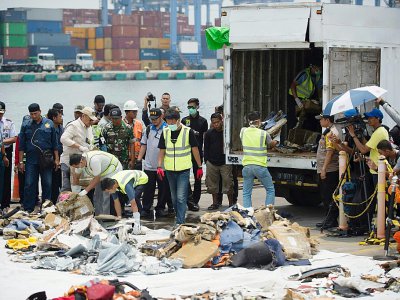 Le 2 novembre 2018 dans un port de Jakarta, les équipes de recherche récupèrent des débris du vol de Lion Air qui s'est abîmé en mer - BAY ISMOYO [AFP]