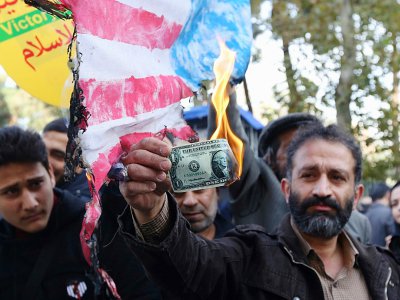 Un Iranien brûle un dollar lors d'une manifestation le 4 novembre 2018 à Téhéran marquant le 39e anniversaire de l'occupation de l'ambassade américaine - ATTA KENARE [AFP]
