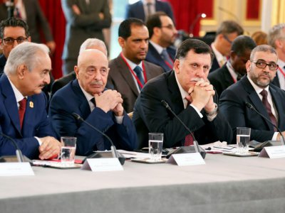 Le Premier ministre du gouvernement libyen internationalement reconnu, Fayez Al-Sarraj (C), et le maréchal Khalifa Haftar (G), l'homme fort de l'est libyen, le 29 mai à Paris lors d'une réunion sur la Libye - Etienne LAURENT [POOL/AFP/Archives]
