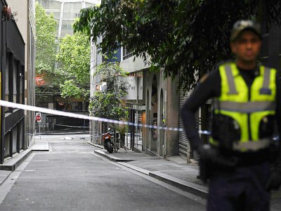 Un corps est allongé sur la chaussée tandis qu'un policier monte la garde après une attaque au couteau le 9 novembre 2018 à Melbourne. - WILLIAM WEST [AFP]