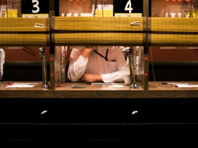 Un client d'un restaurant à Tokyo attend qu'on lui serve son repas dans un compartiment réservé aux personnes seules, le 29 août 2018 - Behrouz MEHRI [AFP]