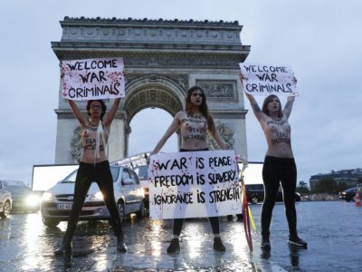 Des militantes Femen manifestent sous l'Arc de Triomphe à Paris, le 10 novembre, pour dénoncer la présence de "criminels de guerre" parmi les chefs d'État invités aux commémorations du 11 novembre - Geoffroy VAN DER HASSELT [AFP]