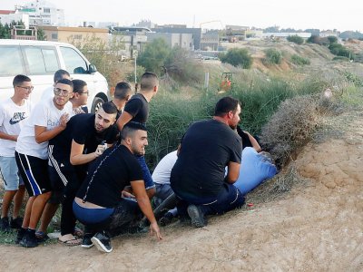 Des Israéliens se mettent à couvert à Sdérot, lors de tirs de roquettes depuis la bande de Gaza voisine, le 13 novembre 2018 - JACK GUEZ [AFP]
