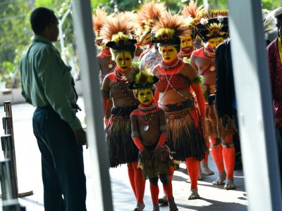 Des Papouasiens en costume traditionnel passent à travers un portique de sécurité devant le Parlement à Port Moresby, le 16 novembre 2018 - Saeed KHAN [AFP]