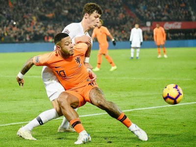 Le Néerlandais Memphis Depay (gauche) tente de récupérer le ballon face au défenseur français Benjamin Pavard - John THYS [AFP]