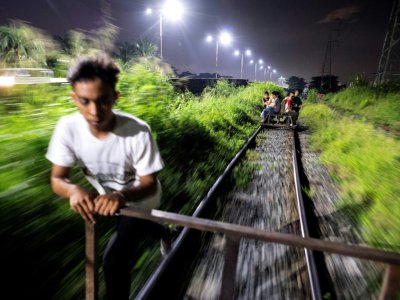 Un "trolley boy" pousse son chariot sur une voie ferrée le 18 octobre 2018 à Manille - Noel CELIS [AFP]