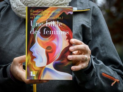 La "Bible des femmes" publiée par une vingtaine de théologiennes, dans les mains d'une des auteures le 20 novembre 2018 à Genève - Fabrice COFFRINI [AFP]