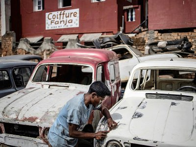 Un jeune carrossier travaille sur une Renault 4L à Antoamadikina, un quartier d'Antananarivo, le 6 novembre 2018 à Madagascar - MARCO LONGARI [AFP]