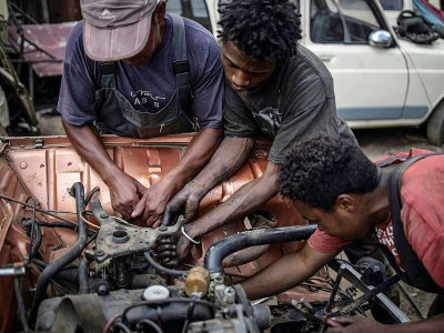 Des jeunes mécaniciens réparent un moteur de Renault 4L à Antoamadikina, le 6 novembre 2018 à Madagascar - MARCO LONGARI [AFP]