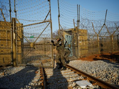 Un soldat sud-coréen ouvre une barrière pour dégager des rails conduisant à la Corée du Nord, le 30 novembre 2018 à Paju, dans la zone démilitarisée séparant les deux Corées - KIM HONG-JI [POOL/AFP]