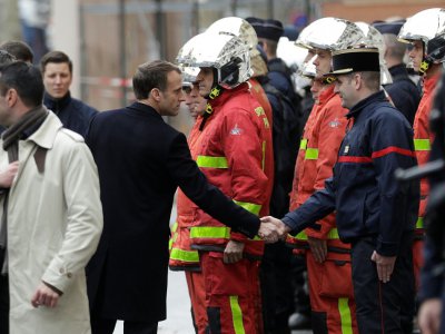 Le président Macron salue les pompiers et gendarmes lors de sa visite dans les rues de Paris, le 2 décembre 2018 au lendemain des manifestations des "gilets jaunes" - Geoffroy VAN DER HASSELT [AFP]