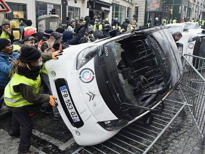Destruction d'une voiture pendant la manifestation des "gilets jaunes" près des Champs-Elysées le 1er décembre 2018 - Lucas BARIOULET [AFP/Archives]