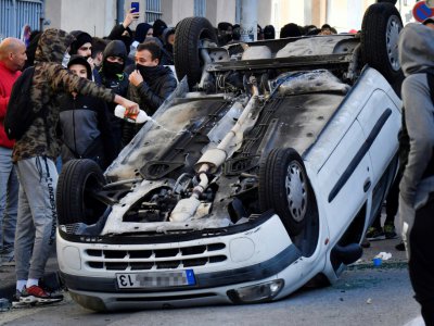 Un jeune asperge de liquide inflammable une voiture renversée lors d'une manifestation de lycéens, le 6 décembre 2018 à Marseille - GERARD JULIEN [AFP]