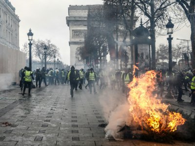 Un sapin brûle sur les Champs-Elysées, le 8 décembre 2018 - Sameer Al-Doumy [AFP]