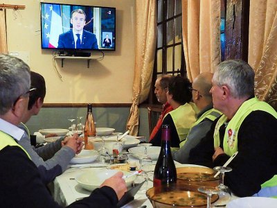 Des "gilets jaunes" écoutent l'allocution d'Emmanuel Macron, le 10 décembre 2018 à Fay-au-Loges, près d'Orléans - GUILLAUME SOUVANT [AFP]