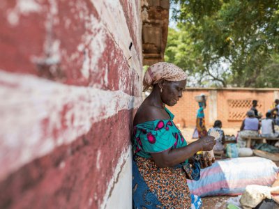 Une femme attend qu'on lui propose un échange de marchandises sur le marché du troc à Togoville, le 24 novembre 2018 - Yanick Folly [AFP]