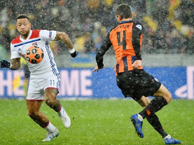 L'attaquant de Lyon Memphis Depay (g) face au défenseur du Shakhtar Donetsk Serhiy Kryvtsov en Ligue des champions, le 12 décembre 2018 à Kiev - SERGEI SUPINSKY [AFP]