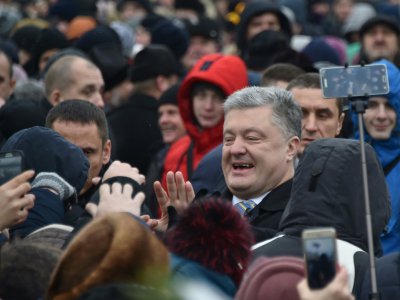 Le président ukrainien Petro Porochenko (C) salue des manifestants réunis devant la cathédrale Sainte-Sophie à Kiev avant un concile historique, le 15 décembre 2018 - Genya SAVILOV [AFP]