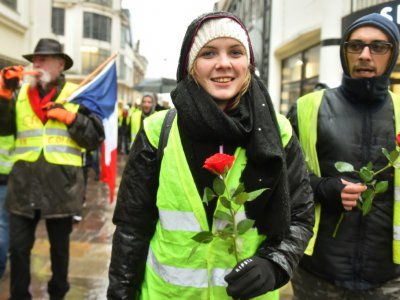 Des "gilets jaunes" avec une rose, en hommage aux victimes de Strasbourg, défilent le 15 décembre 2018 au Mans - JEAN-FRANCOIS MONIER [AFP]