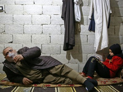 Mohamed Ali al-Hassan et sa fille Cédra, des déplacés syriens, sont installés dans leur chambre dans une cave de la ville d'Al-Bab (nord de la Syrie), où il vivent grâce à l'aide d'associations caritatives, le 7 décembre 2018 - Nazeer AL-KHATIB [AFP]