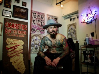 Le barbier Hirotaka Yamakawa montre ses tatouages pour une photo prise le 15 novembre 2017, dans son salon de coiffure, à Tokyo - Behrouz MEHRI [AFP]