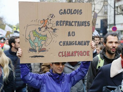 Une femme brandit une pancarte pendant la marche pour le climat à Paris, le 8 décembre 2018 - JACQUES DEMARTHON [AFP/Archives]