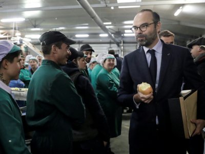 Le Premier ministre Edouard Philippe croque dans une pomme lors de sa visite dans une coopérative, le 21 décembre 2018 à  Saint-Yrieix-la-Perche - Thomas SAMSON [AFP]