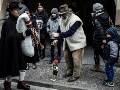 Mario Collino, créateur de jouets d'antan, présente un spectacle de marionnettes dans une rue de Busca, le 16 décembre 2018 en Italie - MARCO BERTORELLO [AFP]