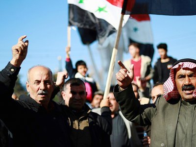 Des Syriens brandissent le drapeau national à Qamishli (ville à majorité kurde dans le nord-est)le 23 décembre 2018, pour demander l'aide de l'armée syrienne contre une offensive turque - Delil SOULEIMAN [AFP]