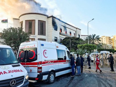 Des ambulances et des responsables de la sécurité sont regroupés à l'extérieur du ministère des Affaires étrangères libyen à Tripoli où a lieu une attaque, le 25 décembre 2018 - Mahmud TURKIA [AFP]