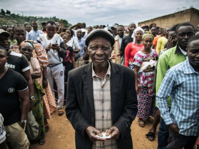 Un homme tient sa carte d'électeur après avoir voté symboliquement à Béni le 30 décembre 2018 en RDCongo - ALEXIS HUGUET [AFP]