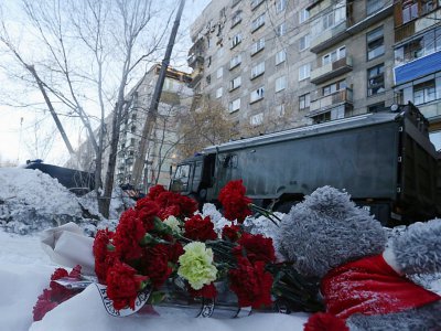 Des fleurs ont été déposées aux abords de l'immeuble touché  par une explosion au gaz à Magnitogorsk, en Russie, en hommage aux victimes, le 1er janvier 2019 - STR [AFP]