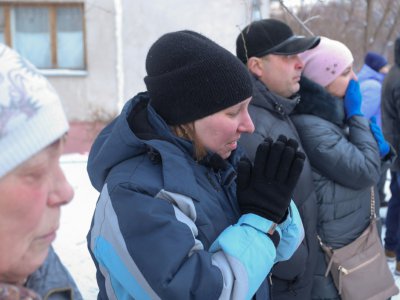Des passants le 1er janvier 2019 à Magnitogorsk en Russie devant le site d'une explosion au gaz qui a ravagé un immeuble d'habitation - STR [AFP]