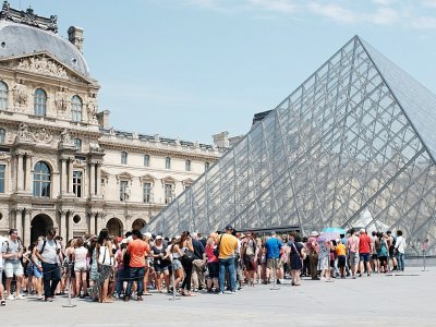 Touristes faisant la queue pour entrer au Louvre, à Paris, le 2 juillet 2015 - MIGUEL MEDINA [AFP/Archives]