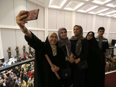 Des spectateurs font un selfie le 3 décembre 2018 à l'hôtel Espinas Palace de Téhéran où se joue avec succès une comédie musicale tirée des "Misérables" - ATTA KENARE [AFP]