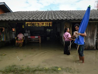 Des habitants remettent en état leur maison inondée après le passage de la tempête Pabuk dans le sud de la Thaïlande, le 5 janvier 2019 - Lillian SUWANRUMPHA [AFP]