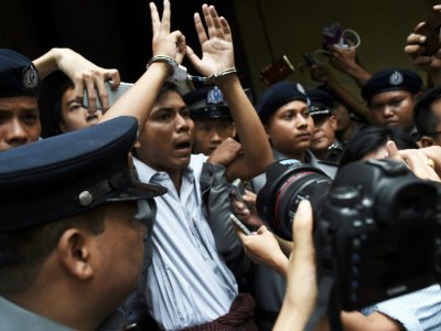 Le journaliste birman Kyaw Soe Oo (c), escorté par des policiers après sa condamnation à sept ans de prison, le 3 septembre 2018 à Rangoun - Ye Aung THU [AFP/Archives]