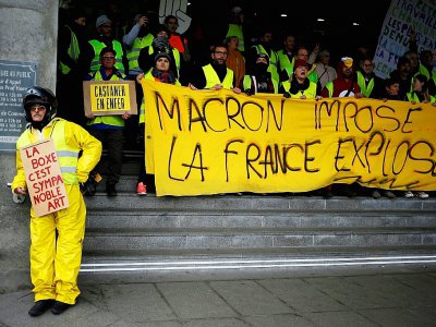 "Gilets jaunes" tenant une banderole "Macron impose, la France explose", à Caen, le 12 janvier 2019 - CHARLY TRIBALLEAU [AFP/Archives]
