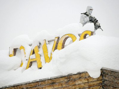Photo d'un agent de sécurité armé sur le toit d'un hôtel de la station de ski suisse Davos où se tient chaque année le Forum économique mondial, prise le 22 janvier 2018 - Fabrice COFFRINI [AFP/Archives]