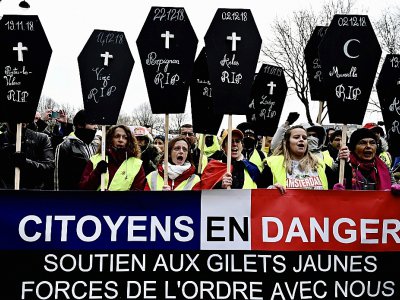 Des "gilets jaunes" manifestent, samedi 19 janvier 2019 à Paris, avec des pancartes en forme de cercueil évoquant les personnes tuées depuis le début du mouvement en novembre - Philippe LOPEZ [AFP]