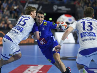 Le Français Ludovic Fabregas (c) à la lutte avec l'Islandais Daniel Thor Ingason (g) au Mondial de handball, le 20 janvier 2019 à Cologne - Patrik STOLLARZ [AFP]