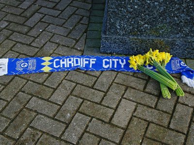 Une écharpe de Cardiff et des jonquilles déposées devant le stade du club, qu'Emiliano Sala devait rejoindre, le 22 janvier 2019 - GEOFF CADDICK [AFP]