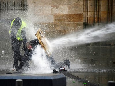 "Gilets jaunes" se protégeant des canons à eau, à Bordeaux, le 26 janvier 2019 - MEHDI FEDOUACH [AFP]