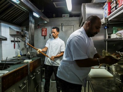 Des chefs préparent des plats pakistanais dans les cuisines du restaurant New Punjab Club, le 16 janvier 2019 à Hong Kong - ISAAC LAWRENCE [AFP]
